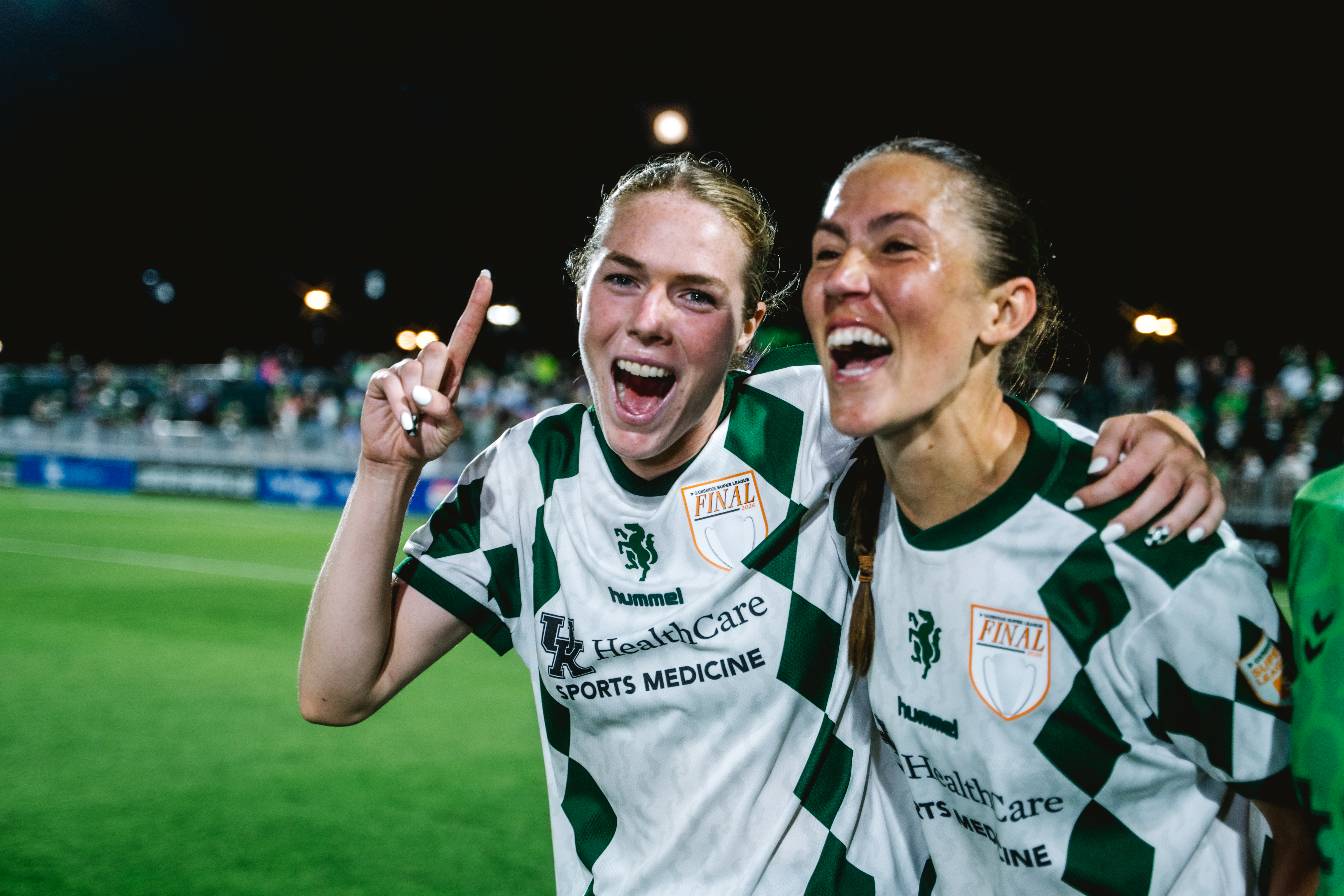 LSC player celebrating with a teammate on the pitch