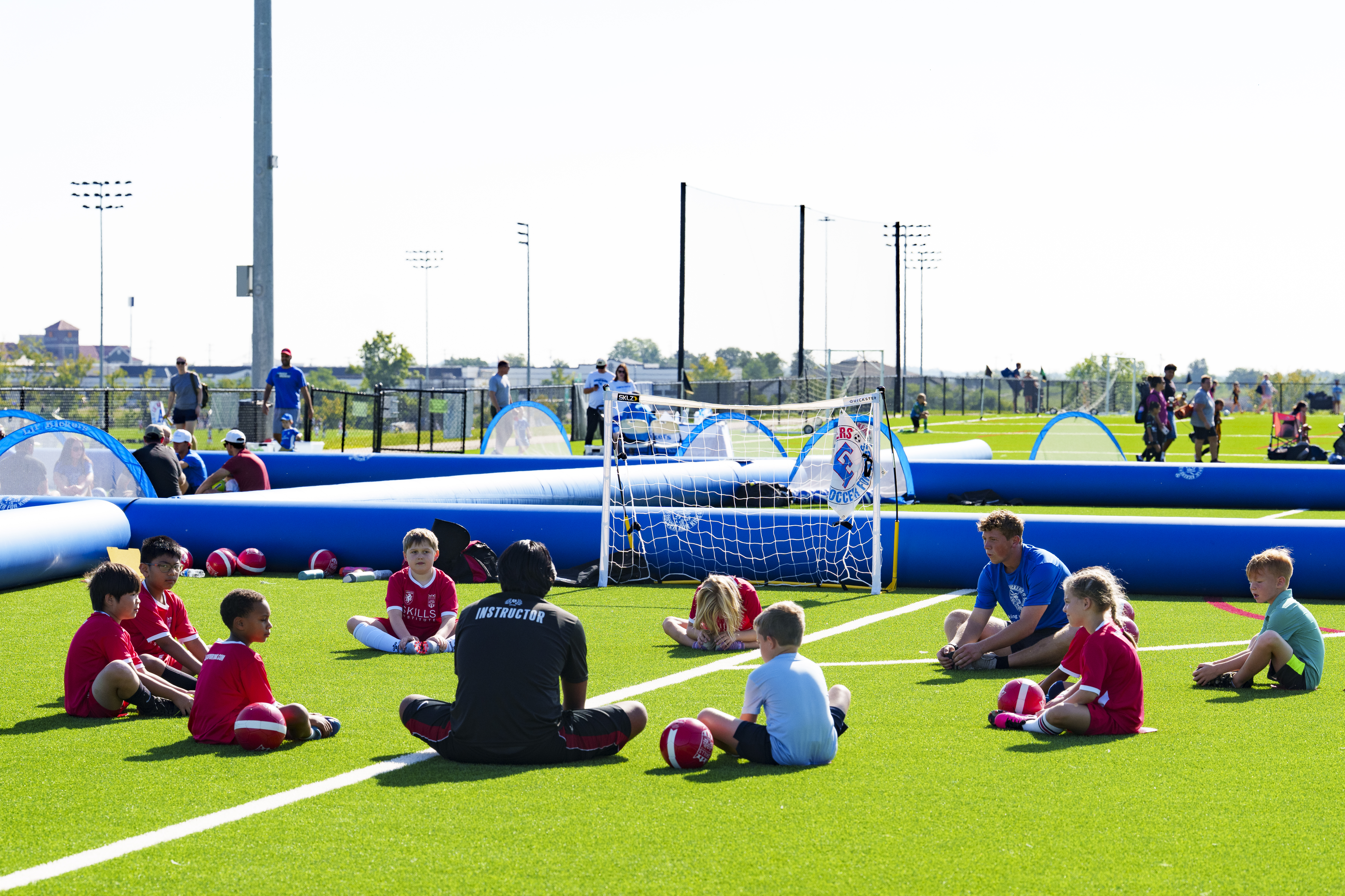 Coach talking with a group of kids on the field