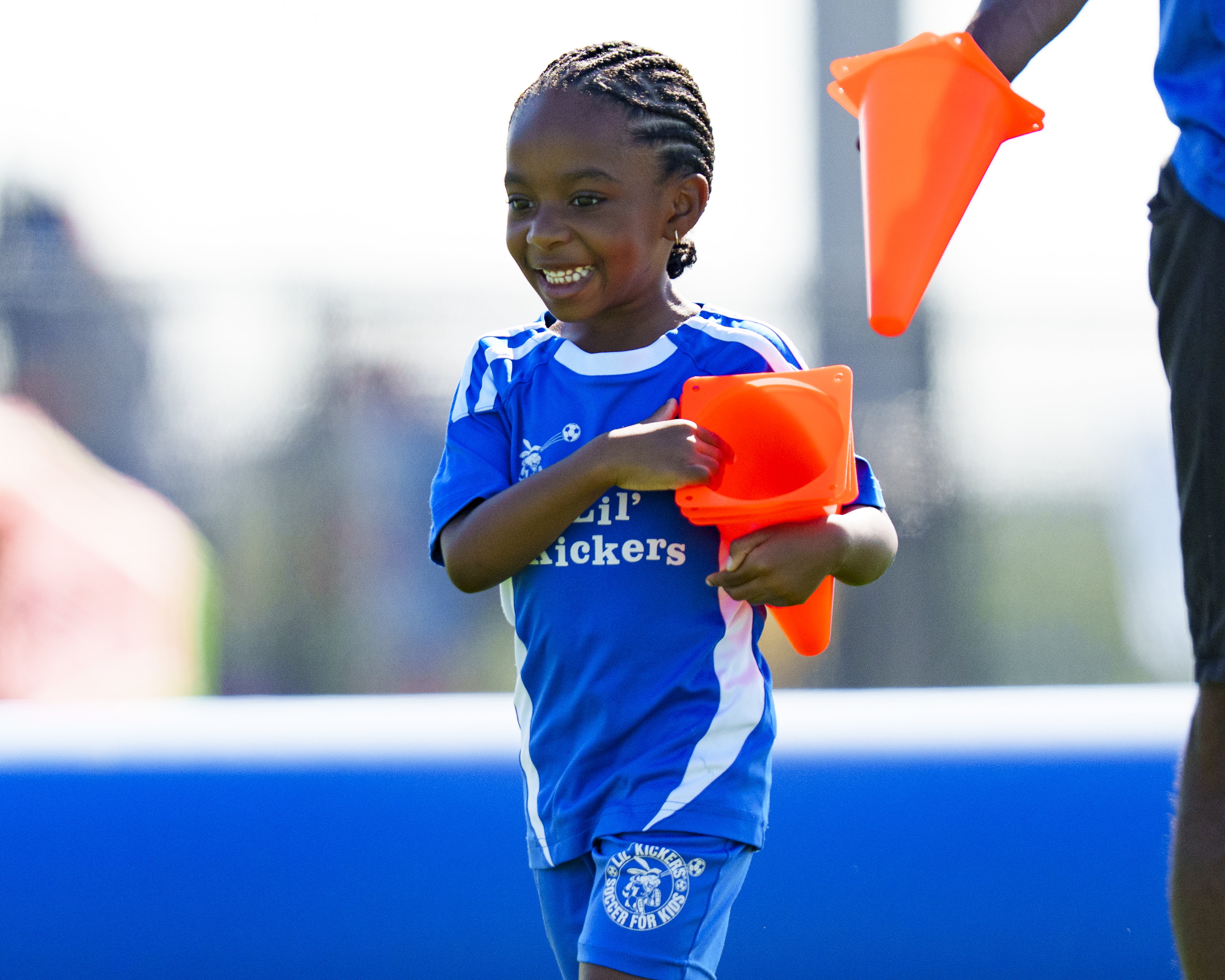 Lil' Kicker holding cones with a smile