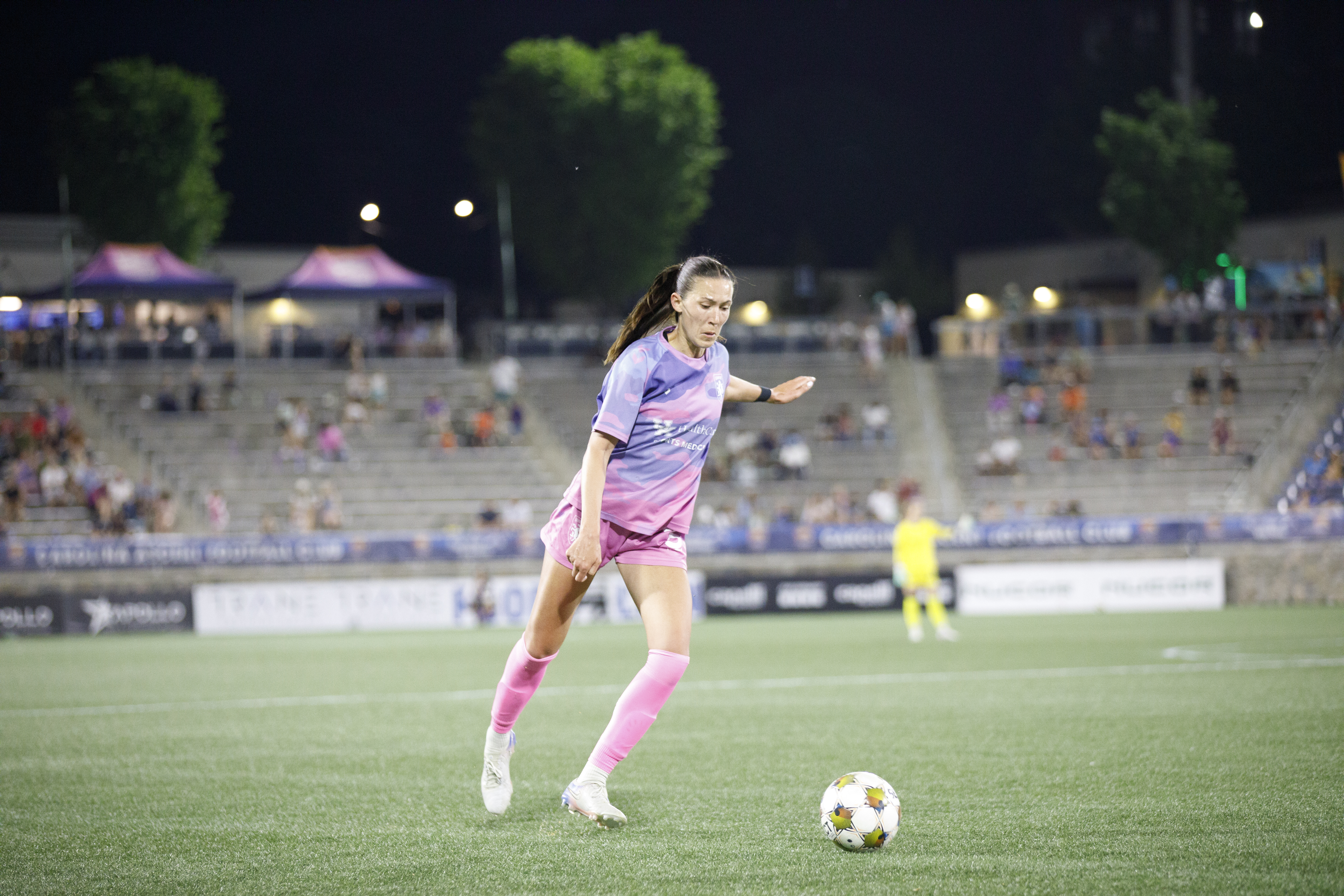 LSC player in a pink alternate kit on the ball